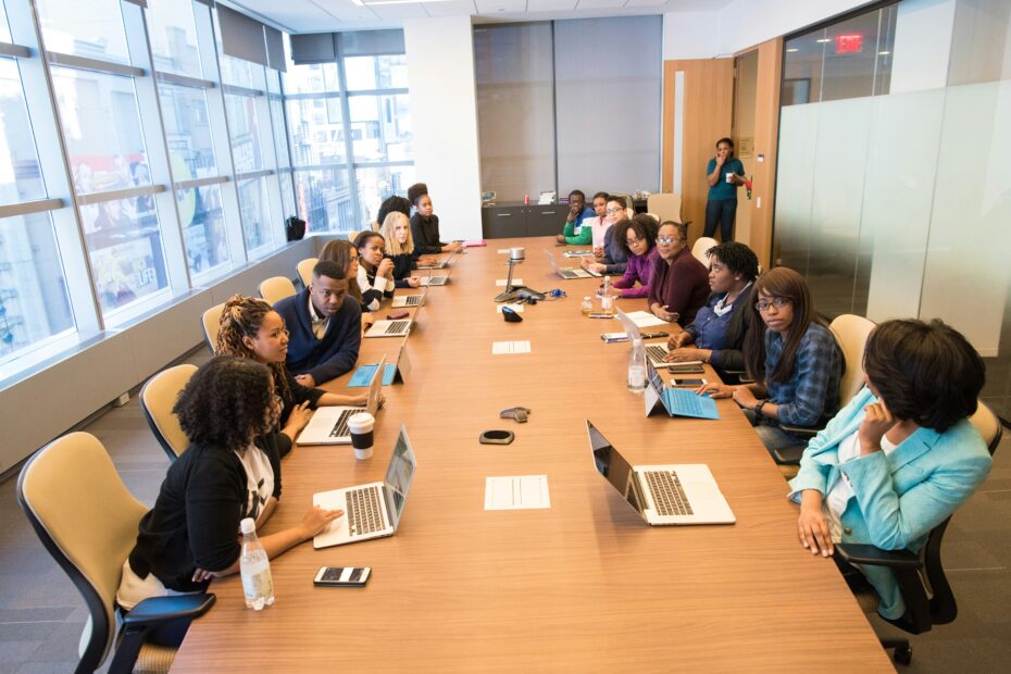 Employees sitting on a rectangle table having a meeting.